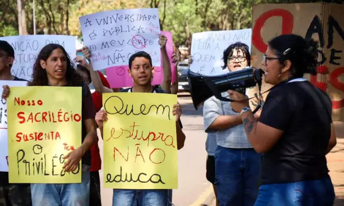 Estudantes com cartazes no campus da UFMS. (Foto: Henrique Kawaminami)