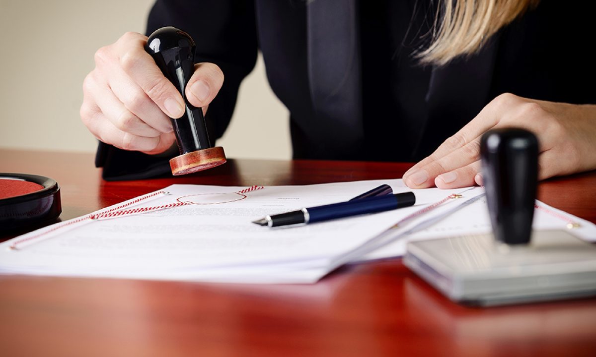 Closeup on notary's public hands stamping document. Notary public accessories