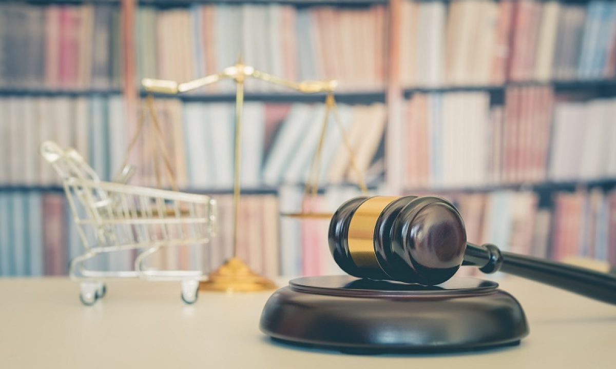 Consumer rights and consimer protection, business law concept : Wooden judge gavel, a shopping cart, a balanced scale of justice on a table, depicting the practice of safeguarding buyers of goods and services.
